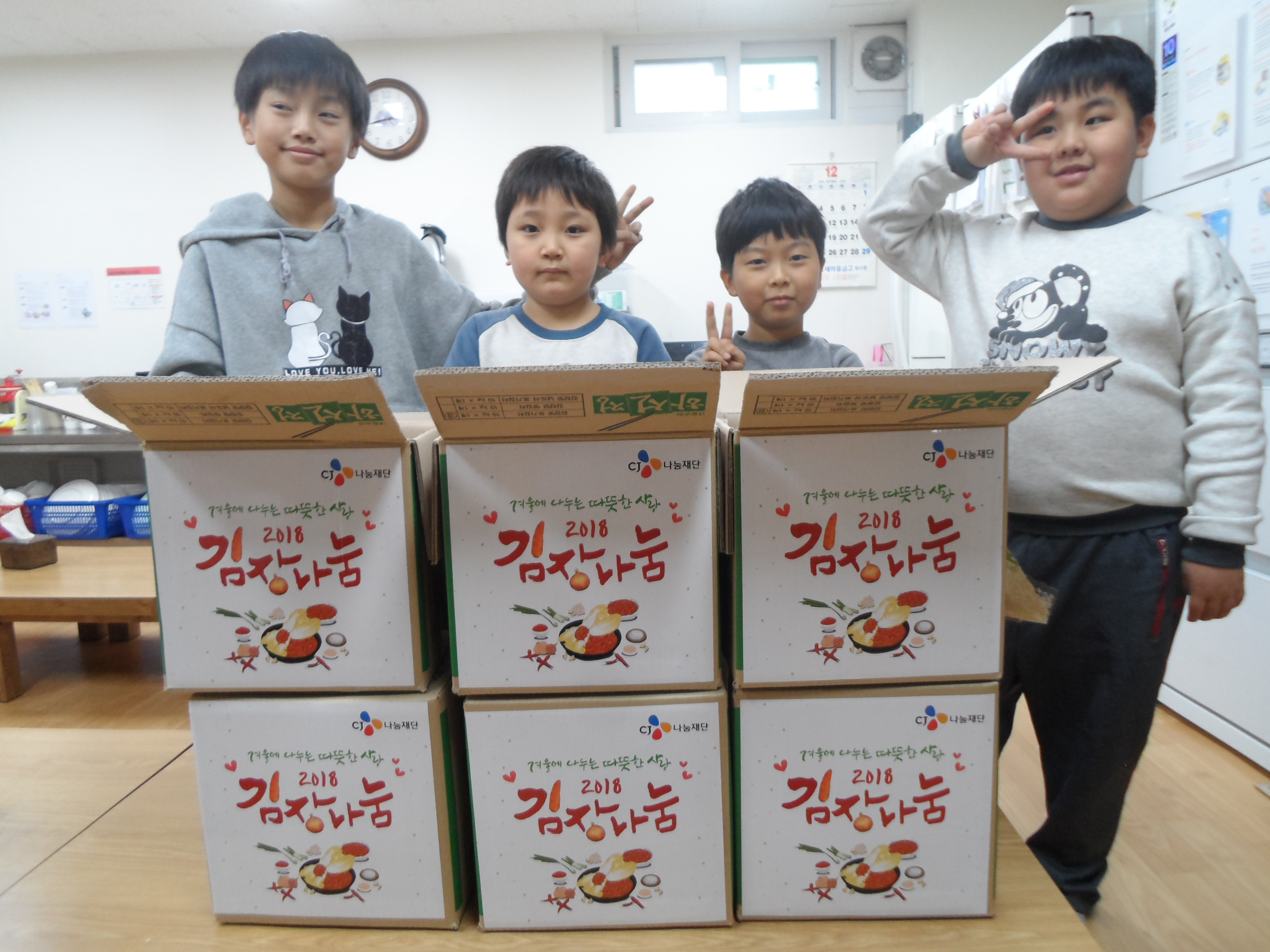 김치 앞에서 활짝 웃고 있는 아동들의 사진입니다.